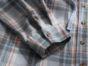 Detail of plaid flannel hooded shirt showing tortoise shell buttons and sleeve cuff