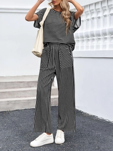 Scatto all'aperto di un completo in maglia a righe bianche e nere da donna con t-shirt e pantaloni