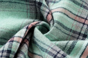 Macro detail of soft light green plaid fabric with navy and pink stripes for autumn hoodies