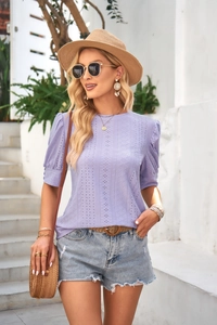 Detail of lavender short sleeve top featuring hollow-out embroidery and puff sleeves