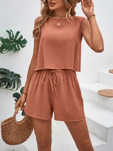 Detail of terracotta sleeveless crop top and drawstring shorts in breathable fabric
