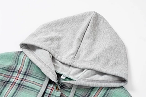 Detail of grey hood and green plaid fabric with size S label on casual shirt jacket