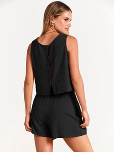 Détail du haut sans manches noir avec fente boutonnée au dos et tissu texturé