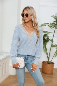 Détail de la bordure en dentelle col V et de la texture côtelée sur ce pull bleu clair