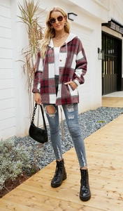 Detail of red and grey plaid hooded flannel jacket styled with ripped jeans and black boots