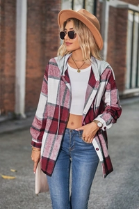 Detail of red and black plaid hooded shirt jacket with grey knit hood on brick wall