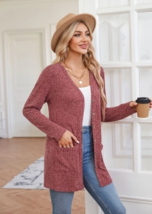 Detailed texture of brick red knit cardigan featuring side pockets and button closure