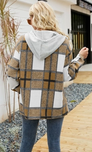 Outdoor shot of a women's oversized brown plaid hooded shacket from a back view