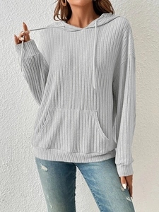 Detail of light grey hooded sweatshirt showing textured vertical rib fabric and kangaroo pocket