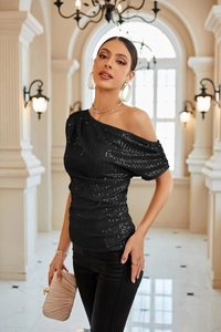 Close-up detail of black sequin one-shoulder top with ruched side and shimmering texture