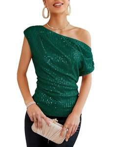 Detailed macro view of dark green sequin fabric with elegant side pleats on the shoulder