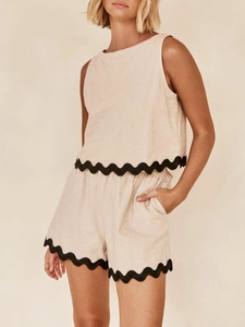 Detail view of oatmeal linen two-piece set featuring black scalloped lace trim on hems