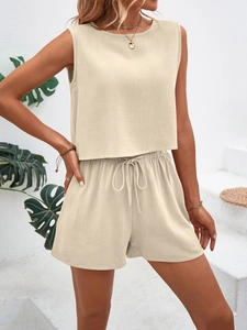 Detailed texture of beige two-piece sleeveless top and drawstring shorts on model