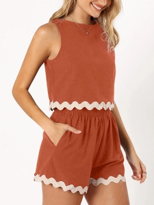 Detail of terracotta two-piece set featuring white scalloped lace edges and side pockets