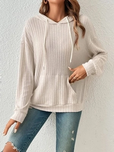 Close-up of beige ribbed knit hoodie featuring adjustable drawstrings and a front kangaroo pocket