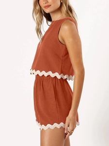 Detail view of brick red linen tank top and shorts featuring white scalloped lace trim edge
