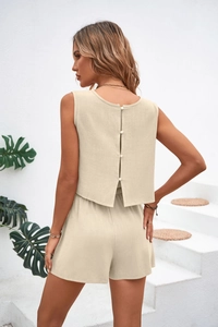 Detail view of the elegant buttoned back slit on an apricot cotton linen set