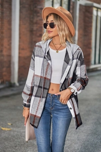 Detail of hooded plaid shacket featuring grey, white, and orange checkered pattern and buttons