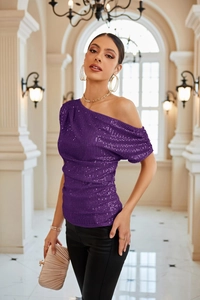 Close-up of sparkling purple sequins and gathered pleats on the one-shoulder top