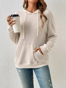 Detail of cream ribbed knit hoodie showing soft texture and kangaroo pocket