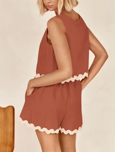 Detail of terracotta two-piece linen set with scalloped white lace trim on shorts and top