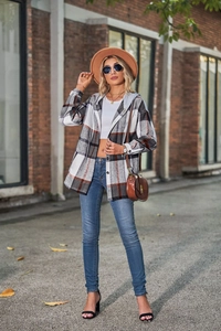 Outdoor shot of a casual hooded plaid shirt jacket in grey and brown for women