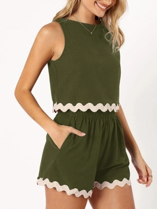 Close-up of olive green linen set showing white scalloped lace trim and fabric texture