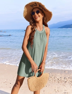 Detail of sage green crochet embroidery on a sleeveless summer halter dress with hollow patterns