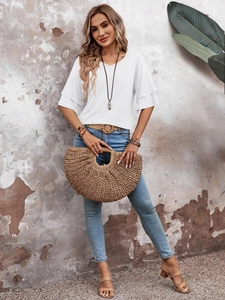 Detailed view of women's white V-neck top with ruffled sleeves and woven handbag