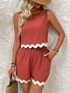 Detail of summer two-piece linen set in brick red with white scallop lace trim decoration