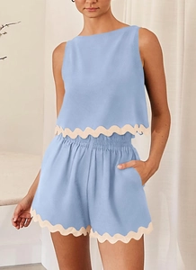 Detail of light blue two-piece set featuring white scalloped lace edges on the hem and shorts