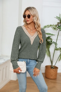 Détail d'un pull gris à col en V avec dentelle élégante et texture maille côtelée fine
