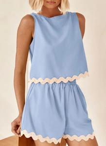 Detail of scalloped lace hem on blue linen two-piece sleeveless top and shorts set