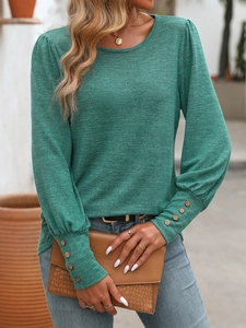 Detail of dark green knit shirt featuring buttoned puff cuffs and textured fabric