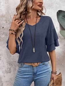 Close-up of V-neckline and layered ruffle sleeves on a navy blue casual summer t-shirt