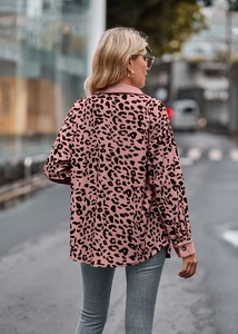 Detail van roze corduroy jas met luipaardprint, lange mouwen en manchetten met knopen