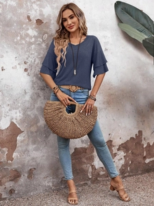Detail of navy V-neck top featuring elegant tiered ruffle sleeves and textured summer fabric