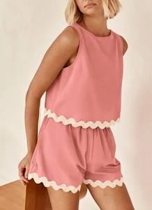 Detail of coral pink linen set featuring cream scalloped lace trim on hem and shorts
