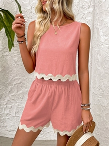 Detail of pink summer two-piece set featuring white scalloped lace trim on hem and shorts