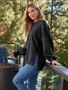 Detail eines schwarzen Rundhals-Sweatshirts mit Seitenschlitz und Ziernaht-Verarbeitung