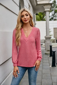 Close-up of pink textured V-neck long sleeve top with soft knit material detail