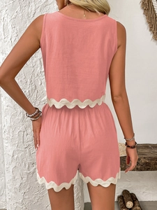 Detail view of the pink summer linen set showing the white lace wave trim on the hem and shorts
