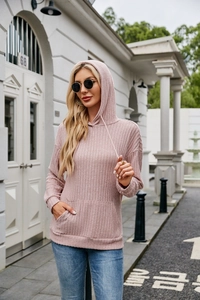 Close-up of pink ribbed knit hoodie featuring drawstring hood and kangaroo pocket