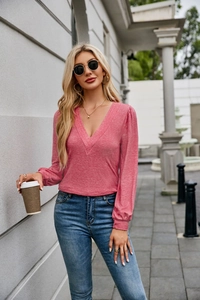 Detail of V-neck pink long sleeve top with layered pleats and knit fabric texture
