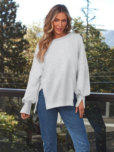 Outdoor-Aufnahme eines hellgrauen Sweatshirts mit Seitenschlitzen am Saum und Rippbündchen