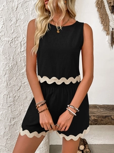 Close-up of black sleeveless top with beige scallop trim and matching casual shorts