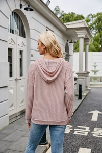 Detail of pink ribbed knit texture on the back of a casual long-sleeved hooded sweater