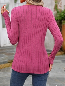 Detail of rose red ribbed knit texture on a slim fit long sleeve top for women