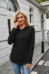 Detail of black ribbed knit hoodie for women featuring a kangaroo pocket and drawstring hood