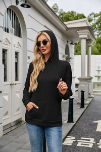 Close-up of black ribbed knit hoodie featuring drawstring hood and functional kangaroo pocket
